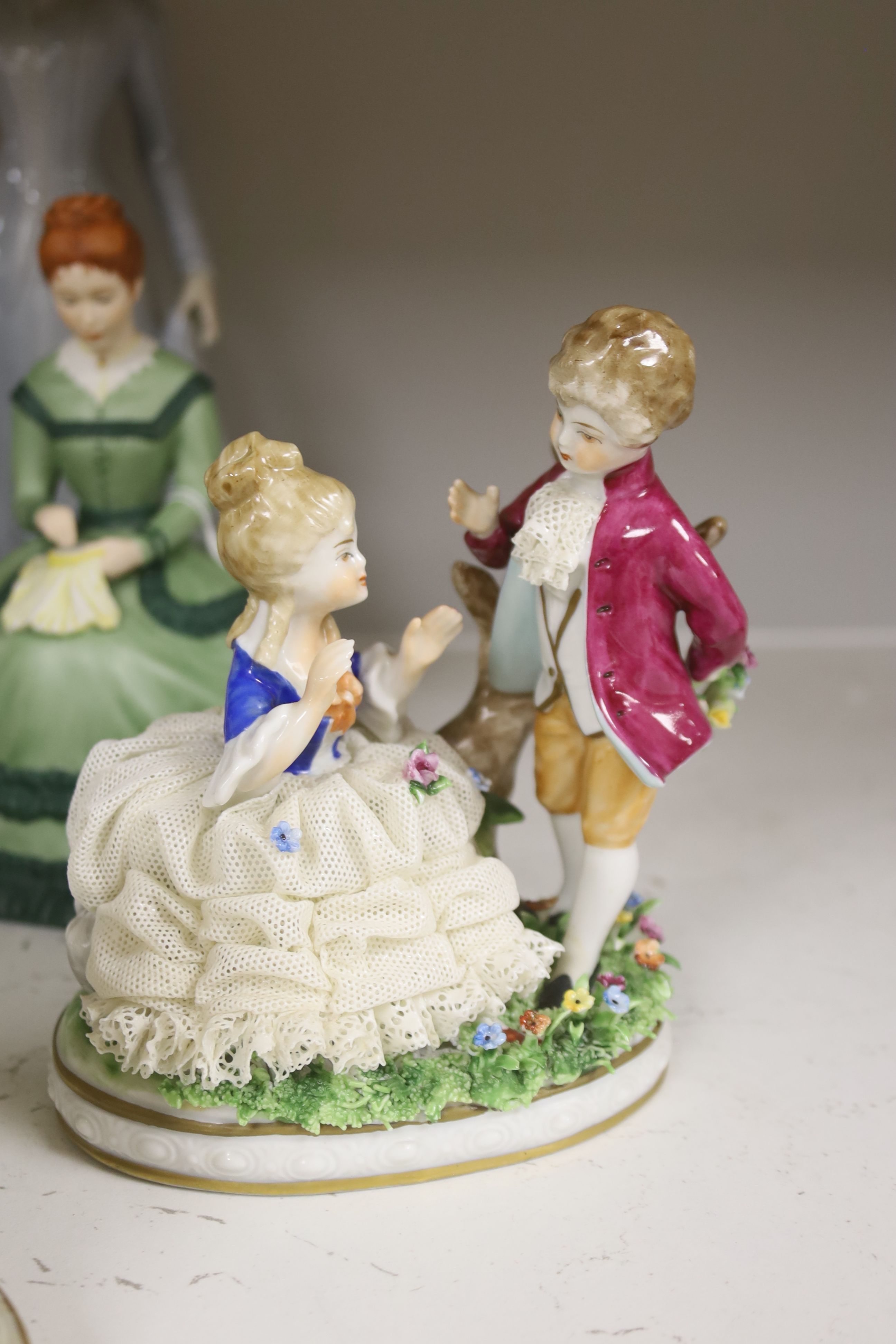 A German porcelain group of two children by a tree stump, on rocky base, two 'crinoline' figures and six other porcelain groups